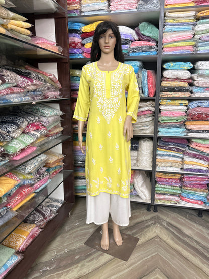 lucknowi chikankari Mannequin wearing a yellow kurta with white patterns in a fabric store.