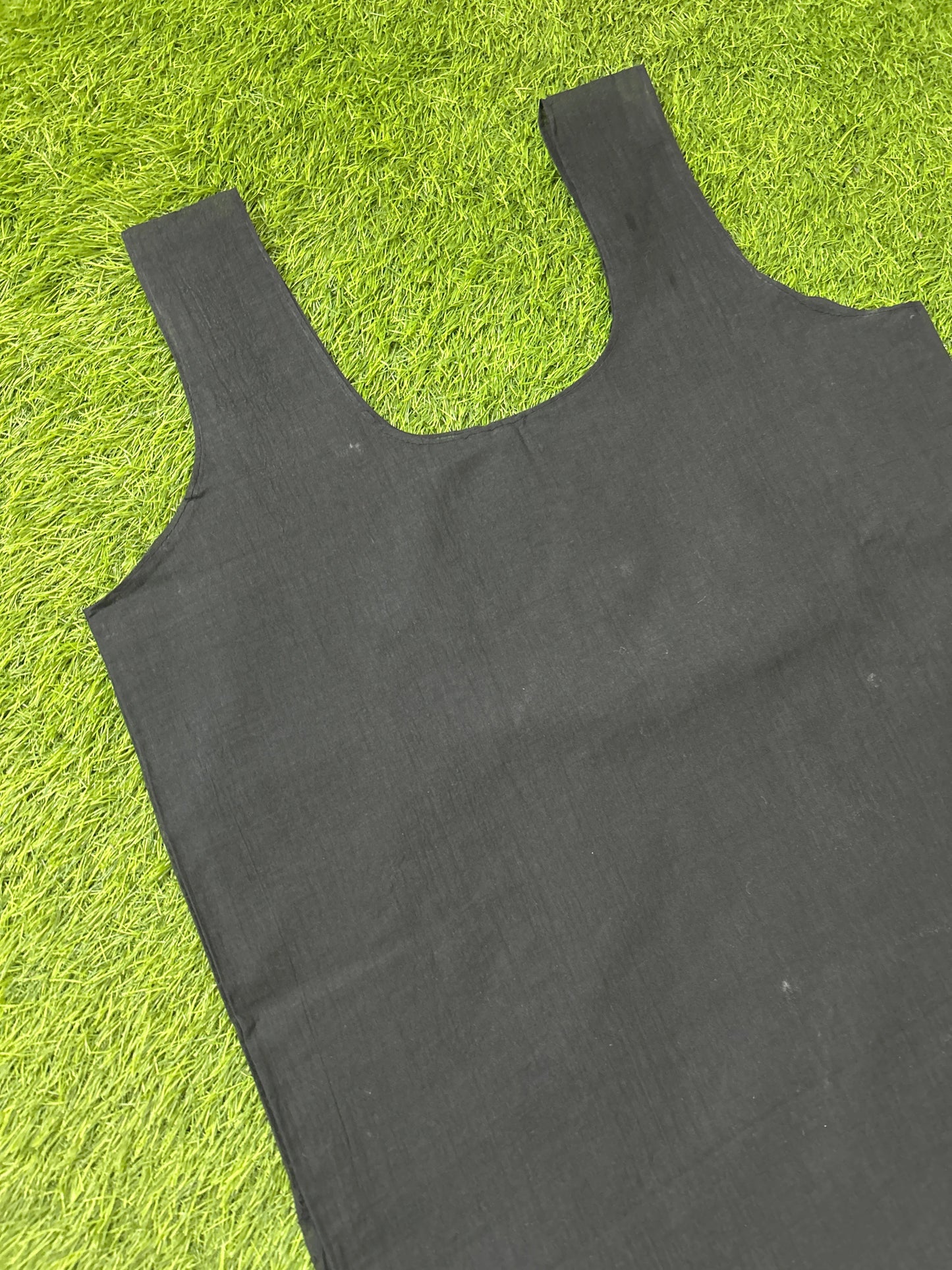 A black slip laid flat on bright green artificial grass.