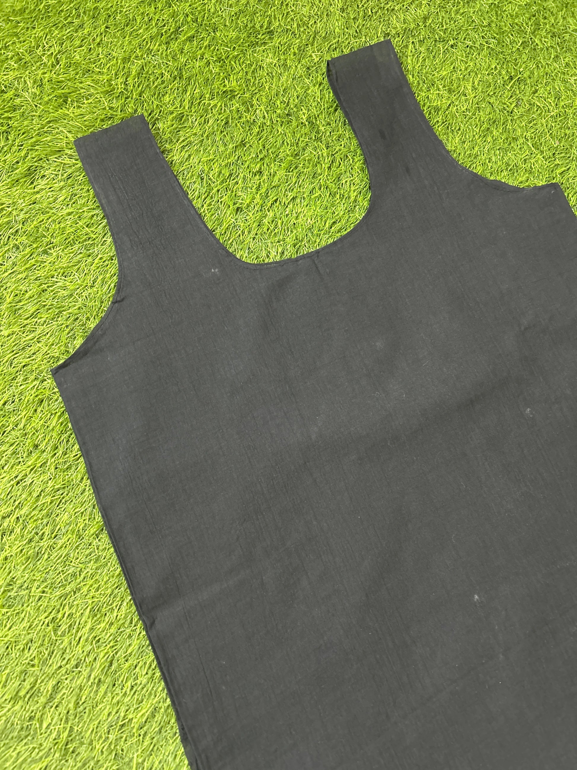 A black slip laid flat on bright green artificial grass.