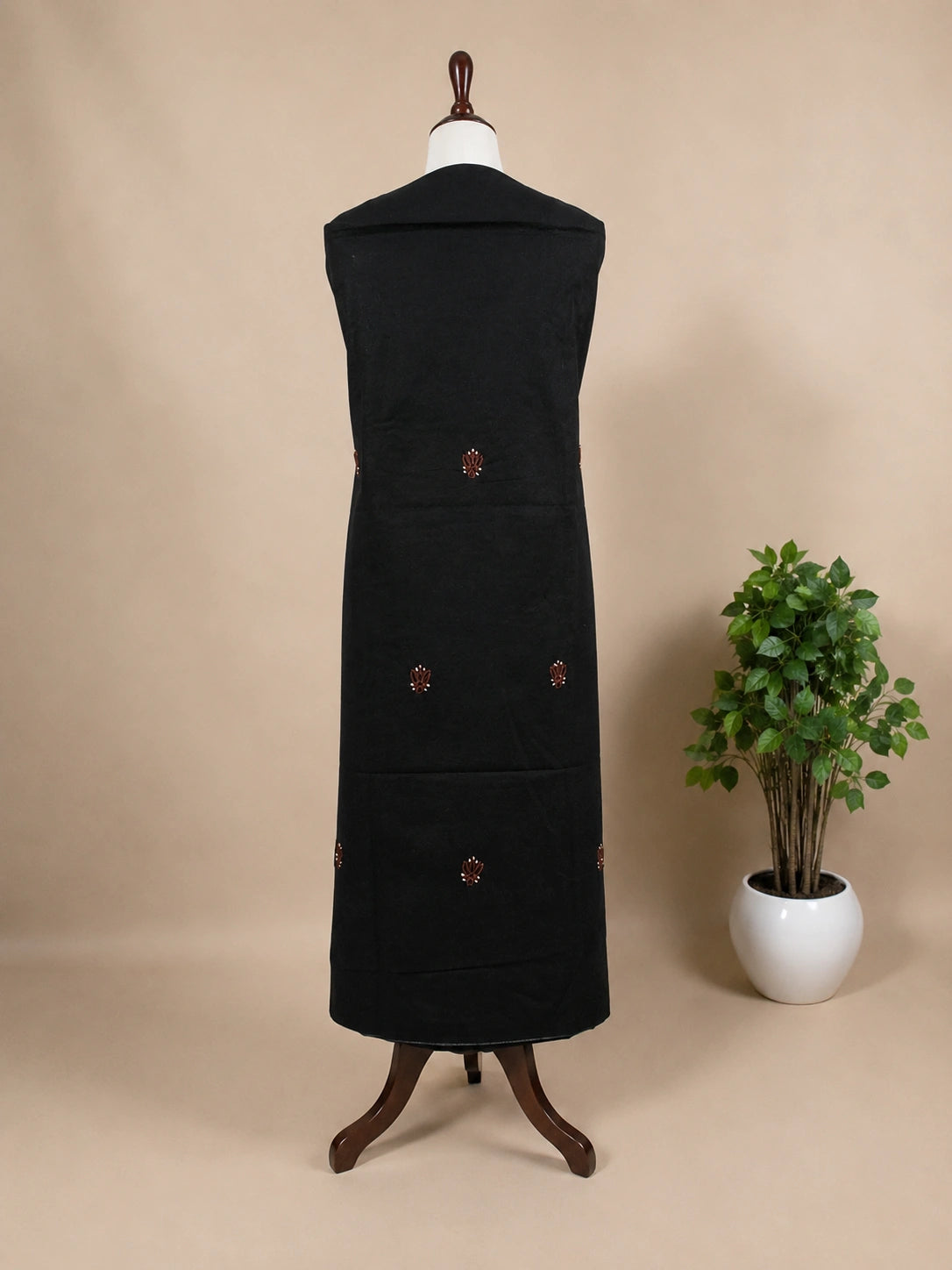 Lucknowi chikankari Black dress on a mannequin with decorative buttons against a beige background
