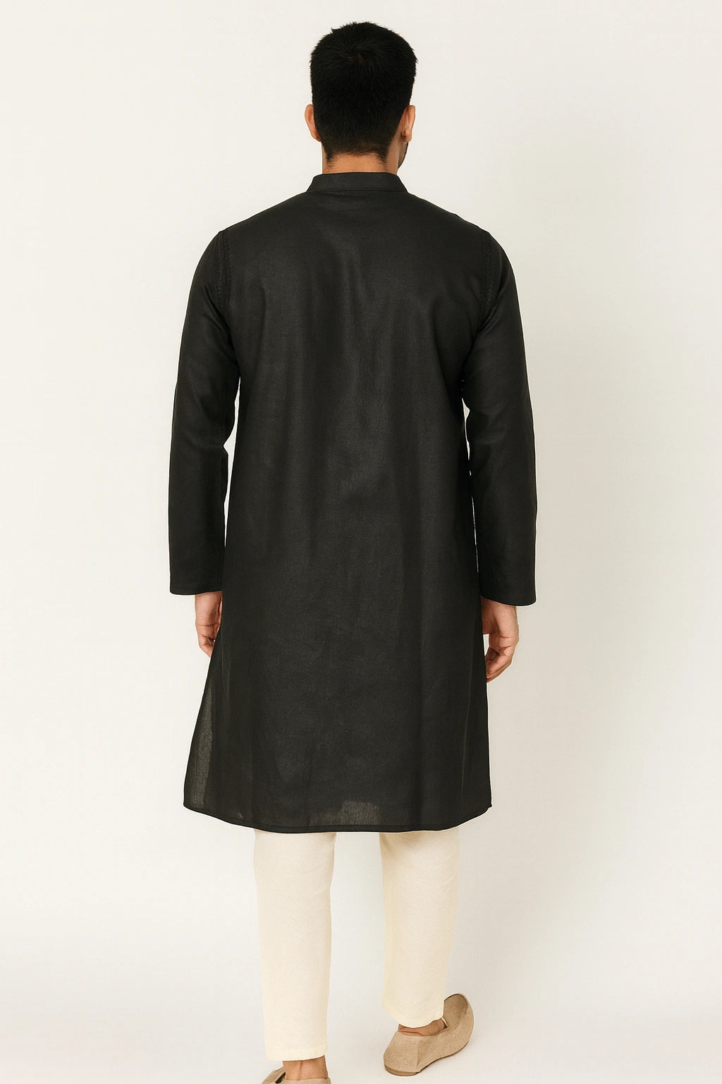 Man wearing a lucknowi chikankari black kurta with white pants on a white background