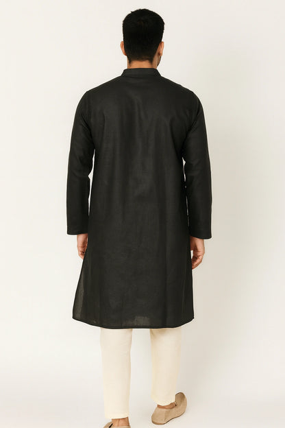 Man wearing a lucknowi chikankari black kurta with white pants on a white background