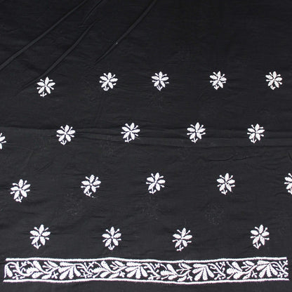 Black fabric with white floral patterns and a decorative border.