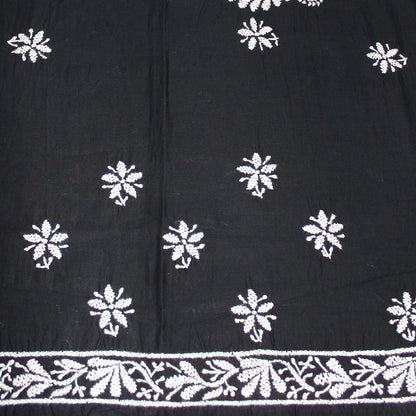 Black fabric with white floral patterns and a decorative border.