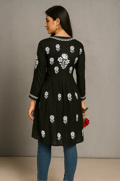 lucknowi chikankari Woman wearing a black dress with white floral patterns against a gray background