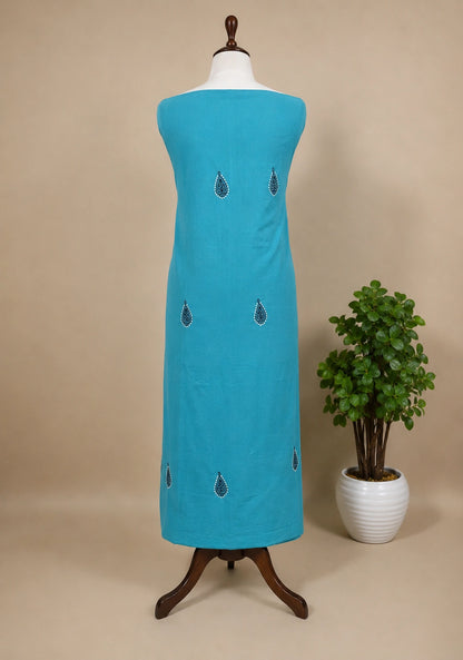 Lucknowi Chikankari Turquoise dress on a mannequin with a plant in the background