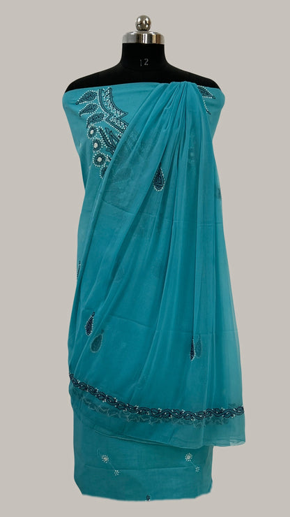 Lucknowi Chikankari Teal saree with decorative patterns on a mannequin against a gray background