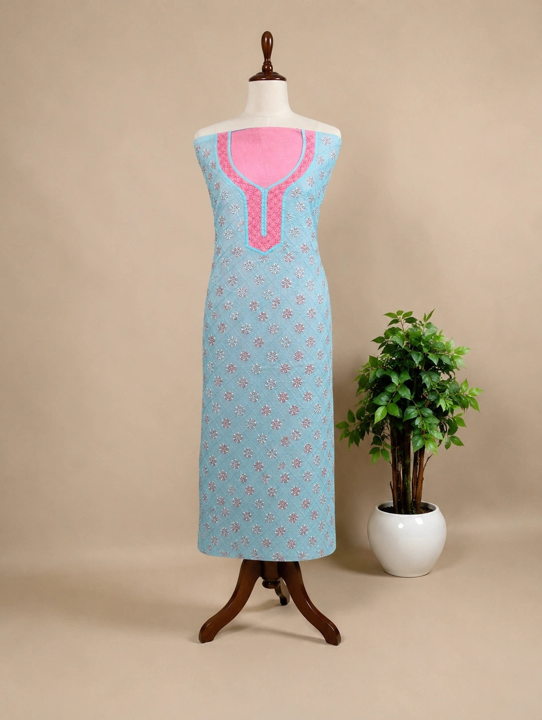 Lucknowi Chikankari Light blue dress with pink neckline on a mannequin against a beige background