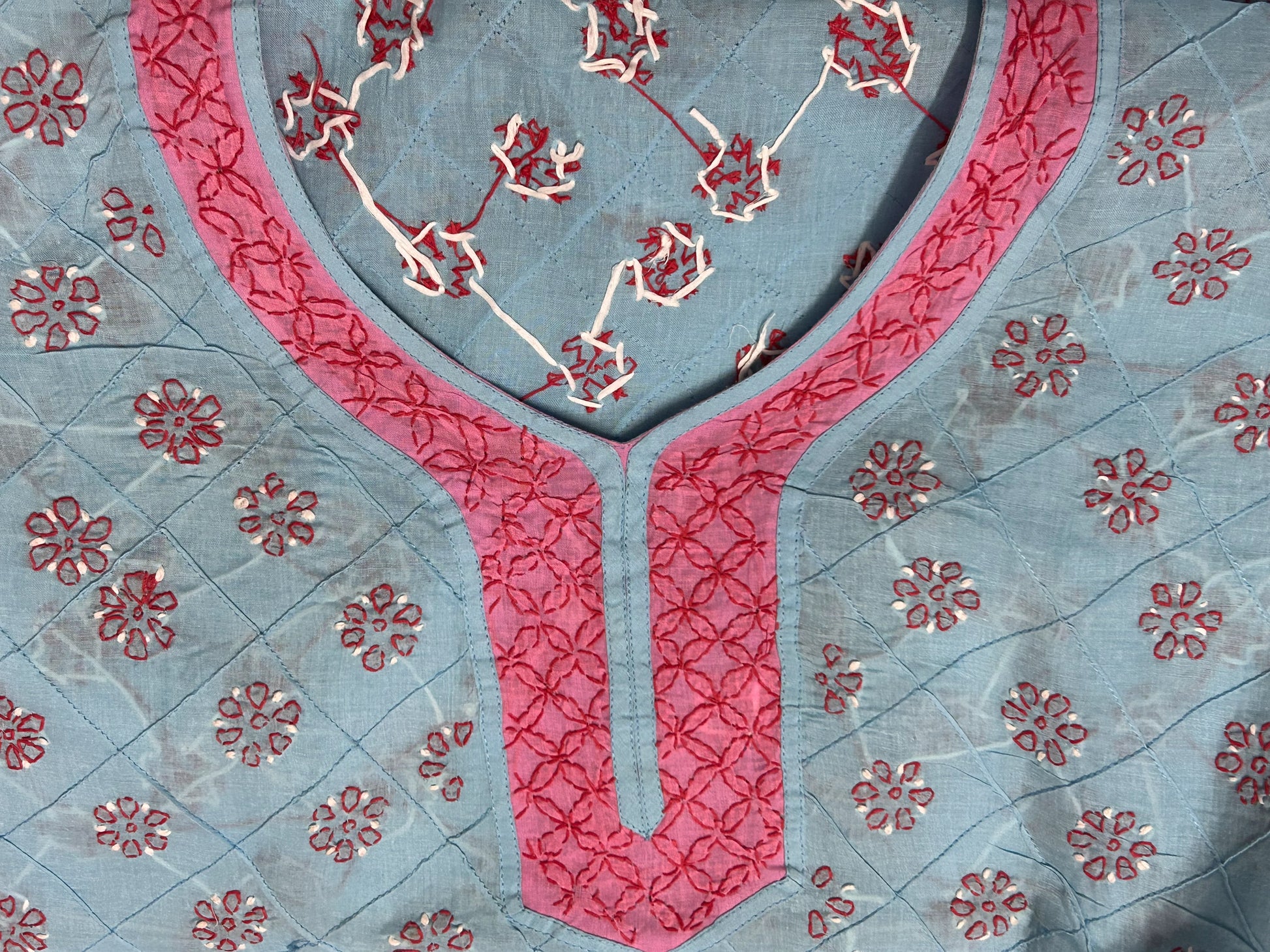 Lucknowi Chikankari Textile with red floral patterns on a blue background