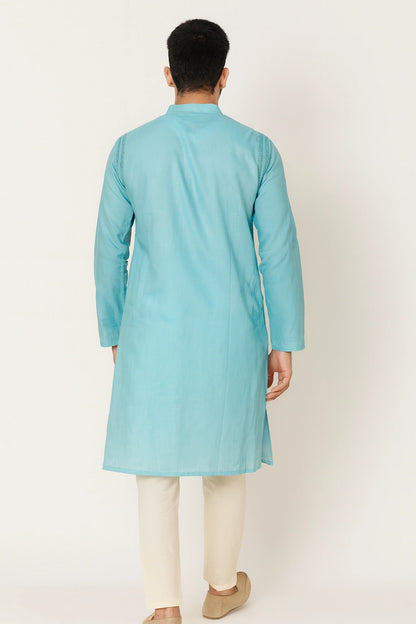 Man wearing a lucknowi chikankari light blue kurta with white pants on a white background
