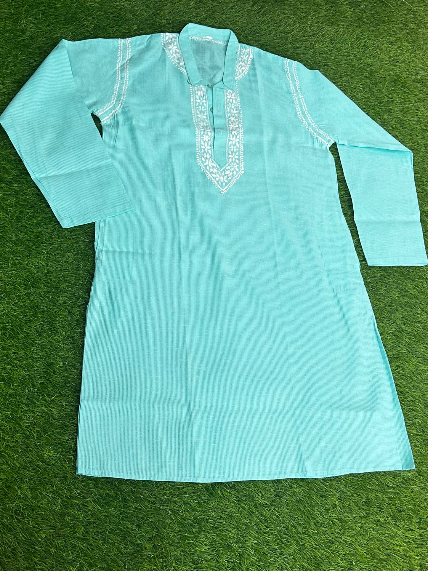 Light blue kurta with white embroidery on a green background