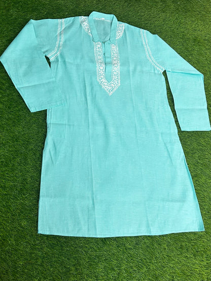 Light blue kurta with white embroidery on a green background