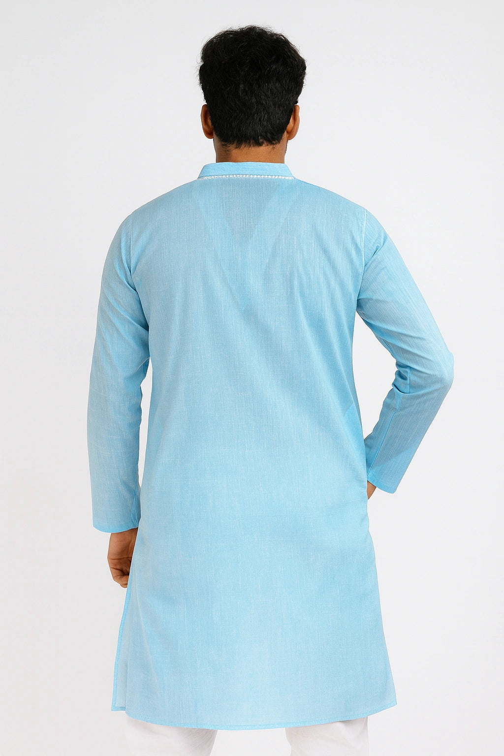 Person wearing a lucknowi chikankari light blue kurta against a white background