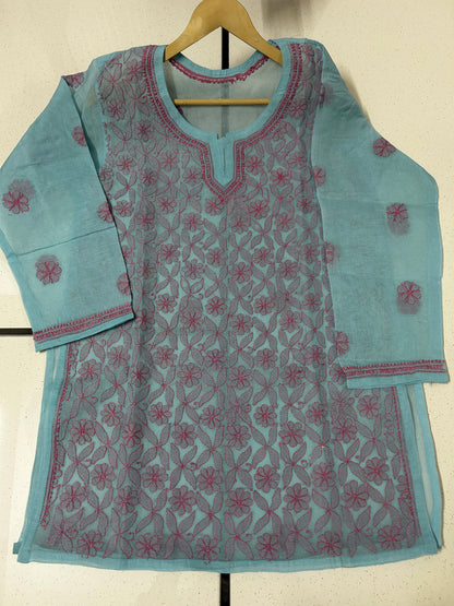 lucknowi chikankari Light blue kurta with pink floral patterns on a hanger against a white wall.