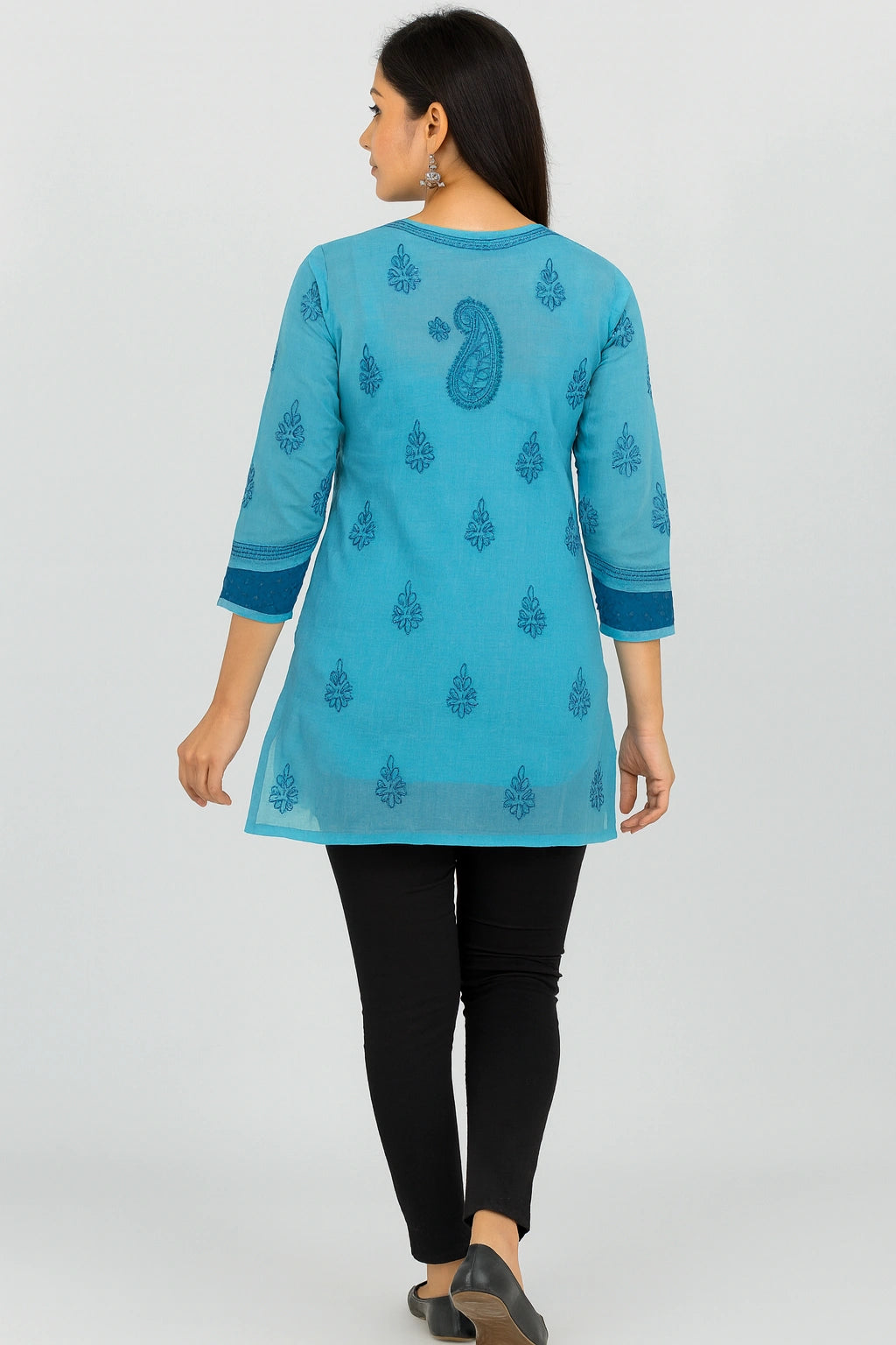 Woman wearing a lucknowi chikankari blue patterned kurta with black pants on a white background