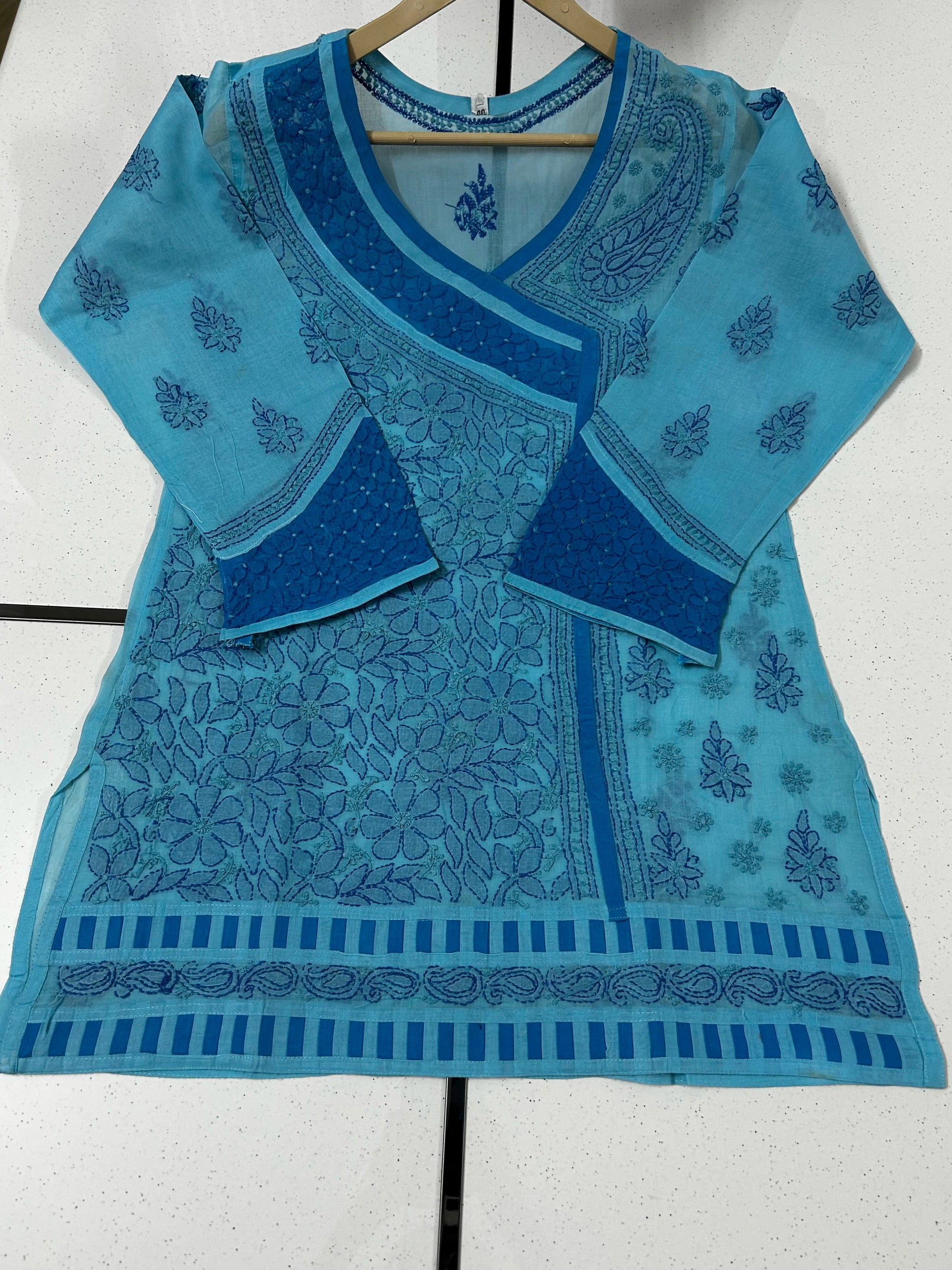 Woman wearing a lucknowi chikankari blue patterned kurta on a white background