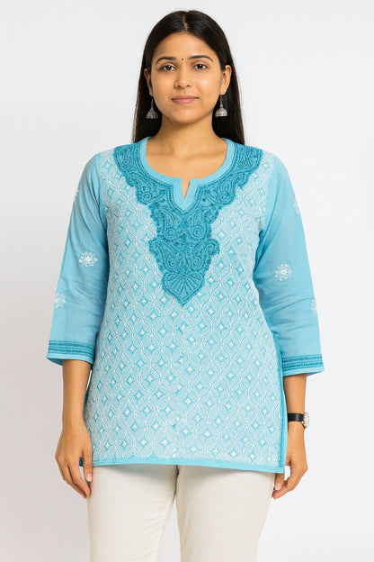 Woman wearing a lucknowi chikankari blue patterned kurta with white pants on a white background