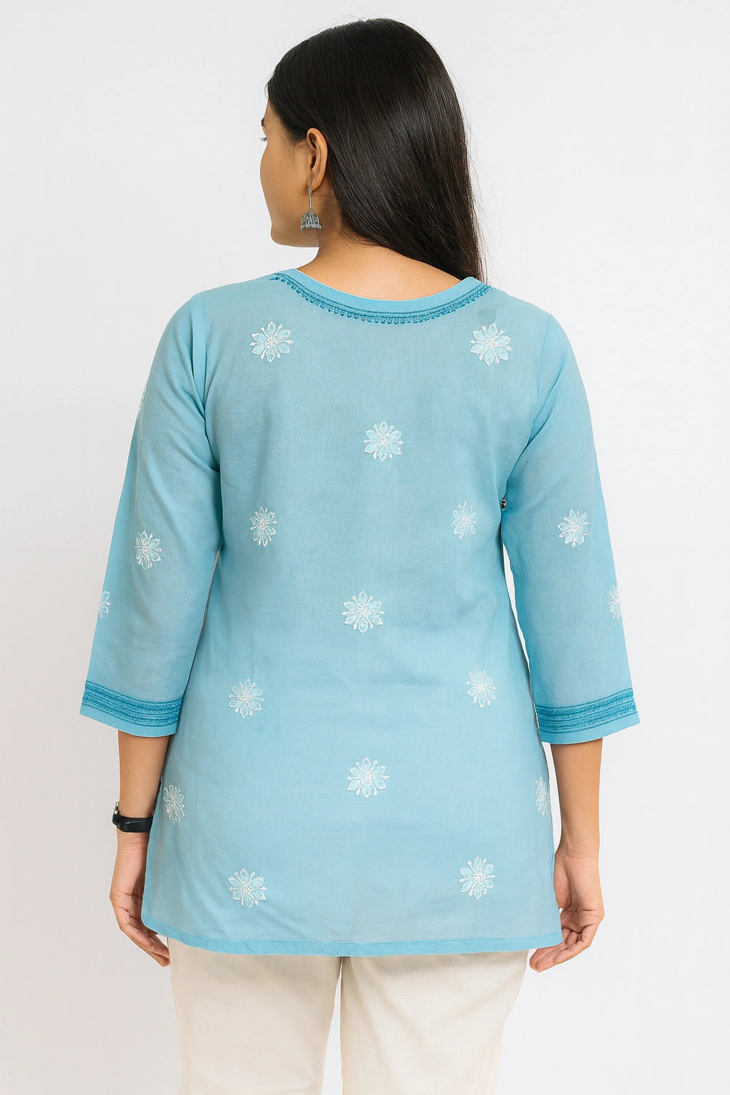 Woman wearing a lucknowi chikankari blue patterned kurta with white pants on a white background