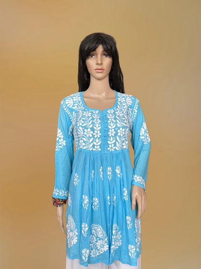 Blue kurta with white floral embroidery on a mannequin against a beige background