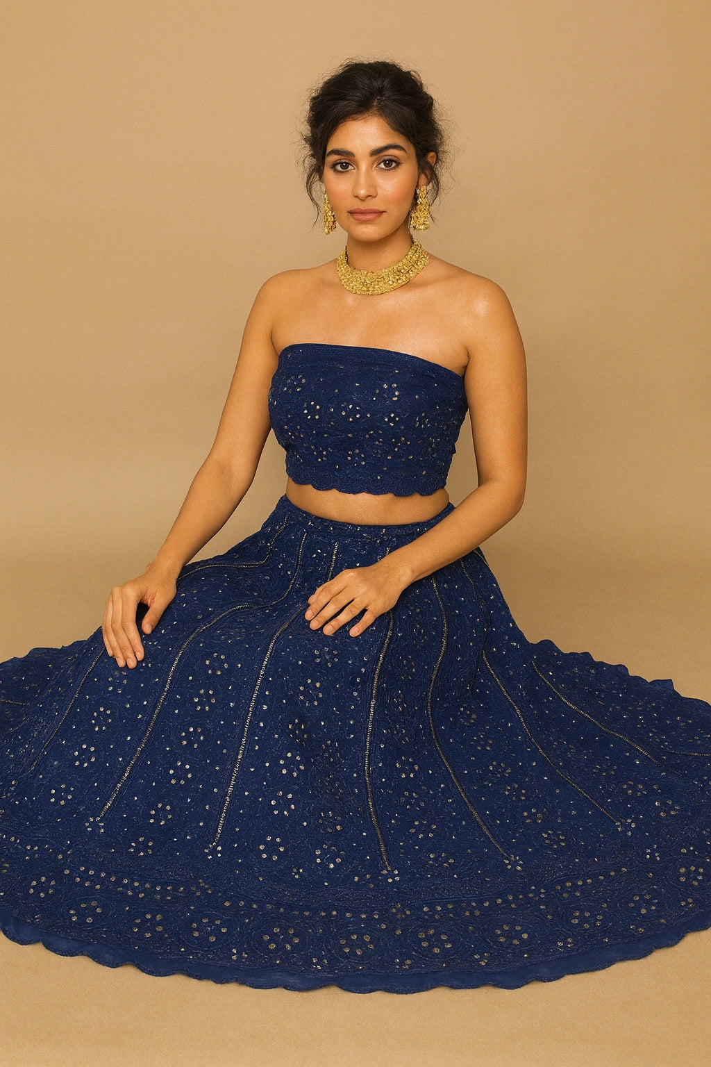 Woman wearing a blue embroidered outfit against a beige background