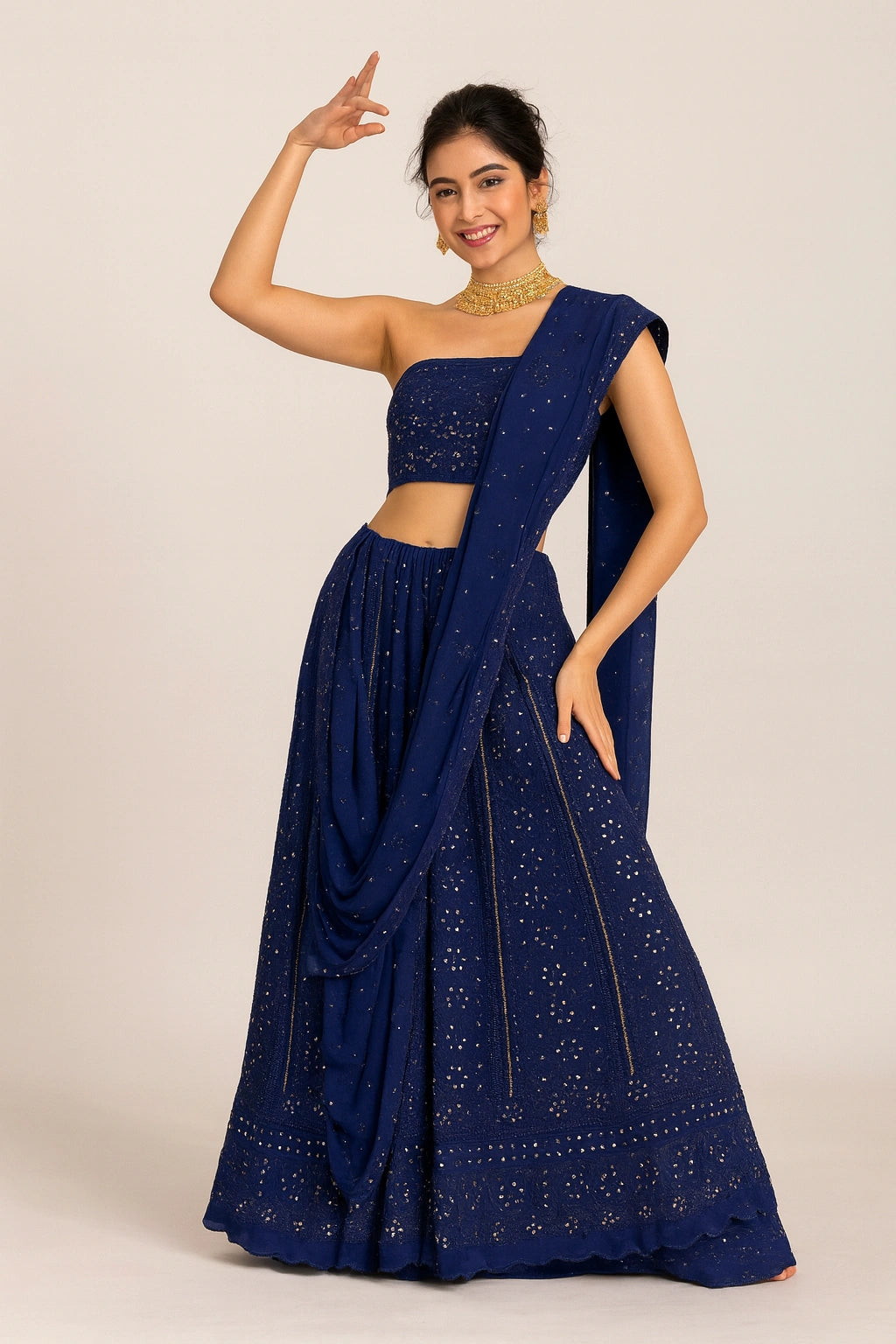 Woman wearing a blue saree with a matching blouse on a beige background