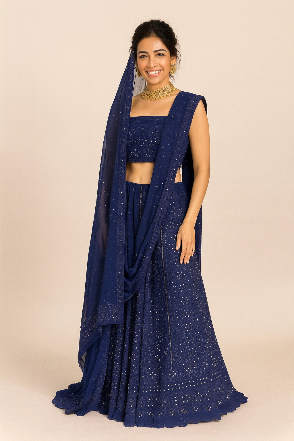 Woman wearing a blue traditional outfit with a matching dupatta on a beige background