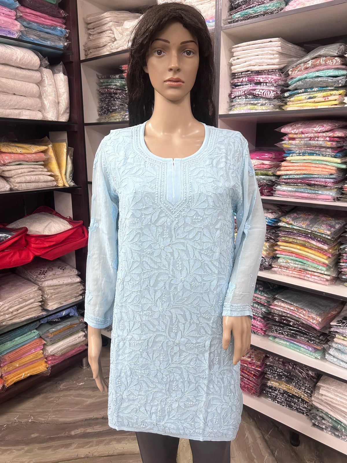 Woman wearing a lucknowi chikankari blue-colored kurta with white patterns on a white background