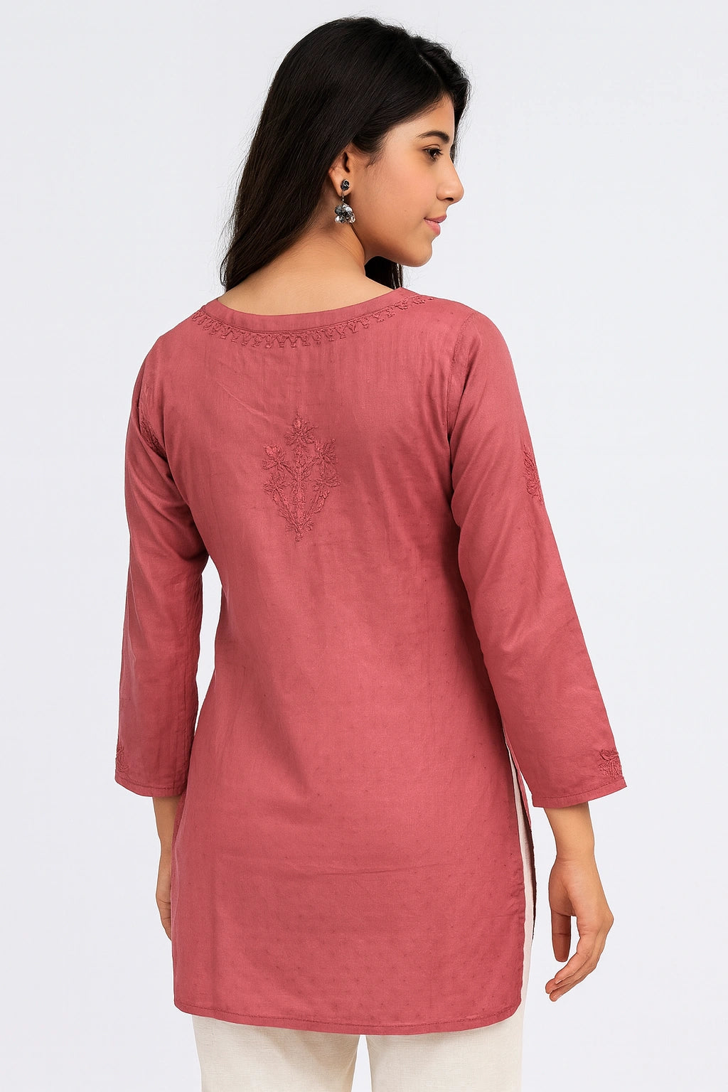 Woman wearing a lucknowi chikankari pink kurta with white background