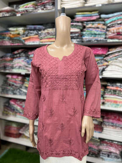 Mannequin wearing a pink embroidered top in a fabric store
