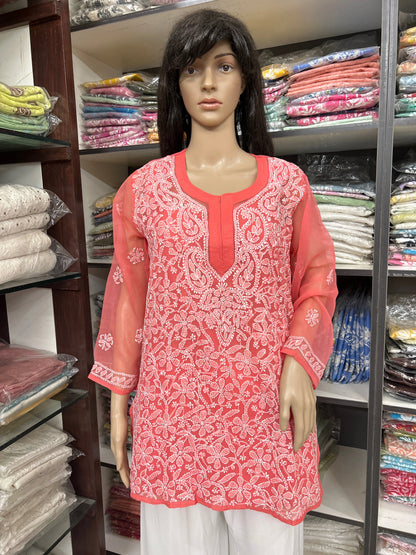 Mannequin wearing a pink embroidered kurta in a fabric store.