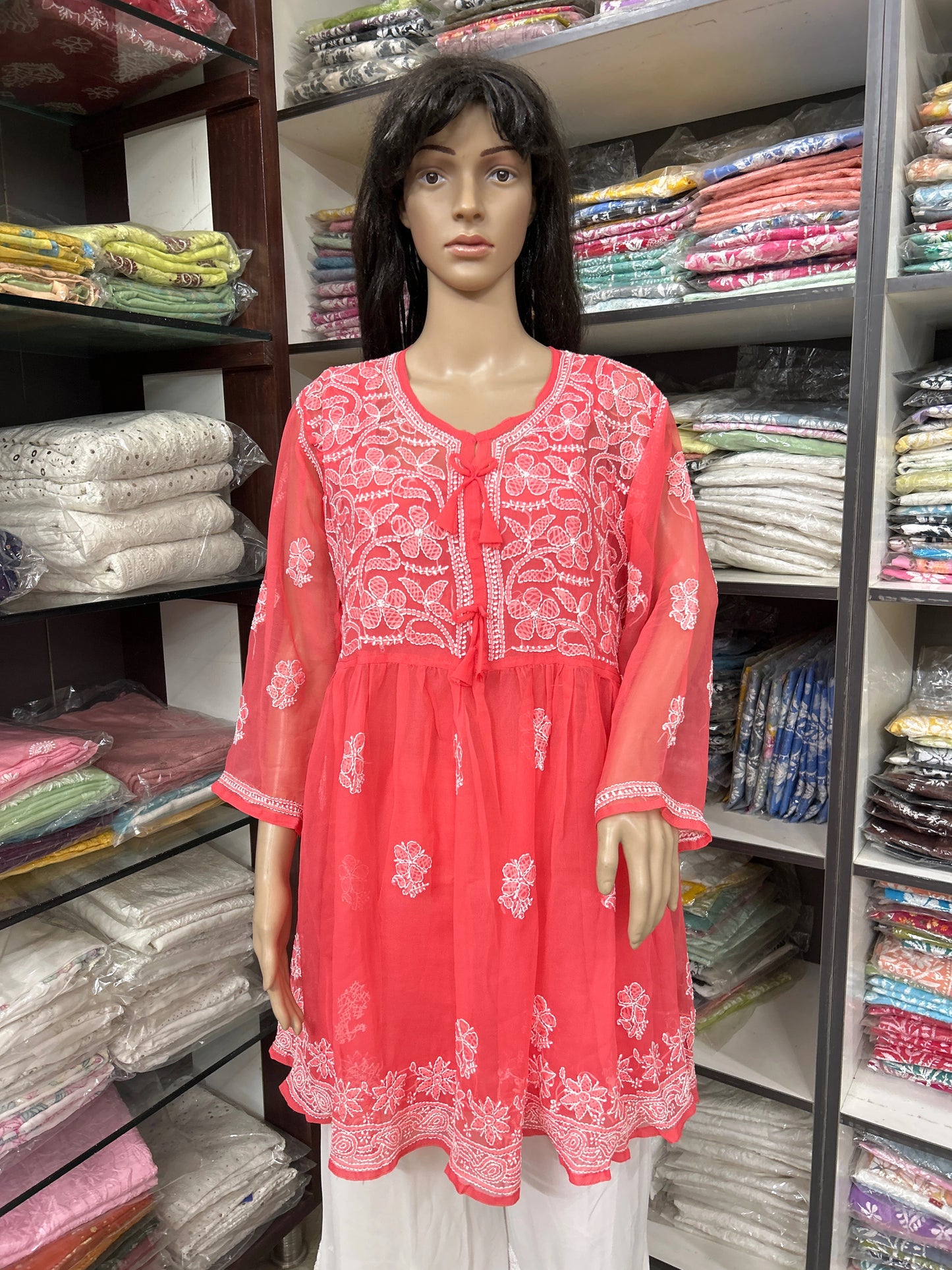 Mannequin wearing a red embroidered top in a fabric store