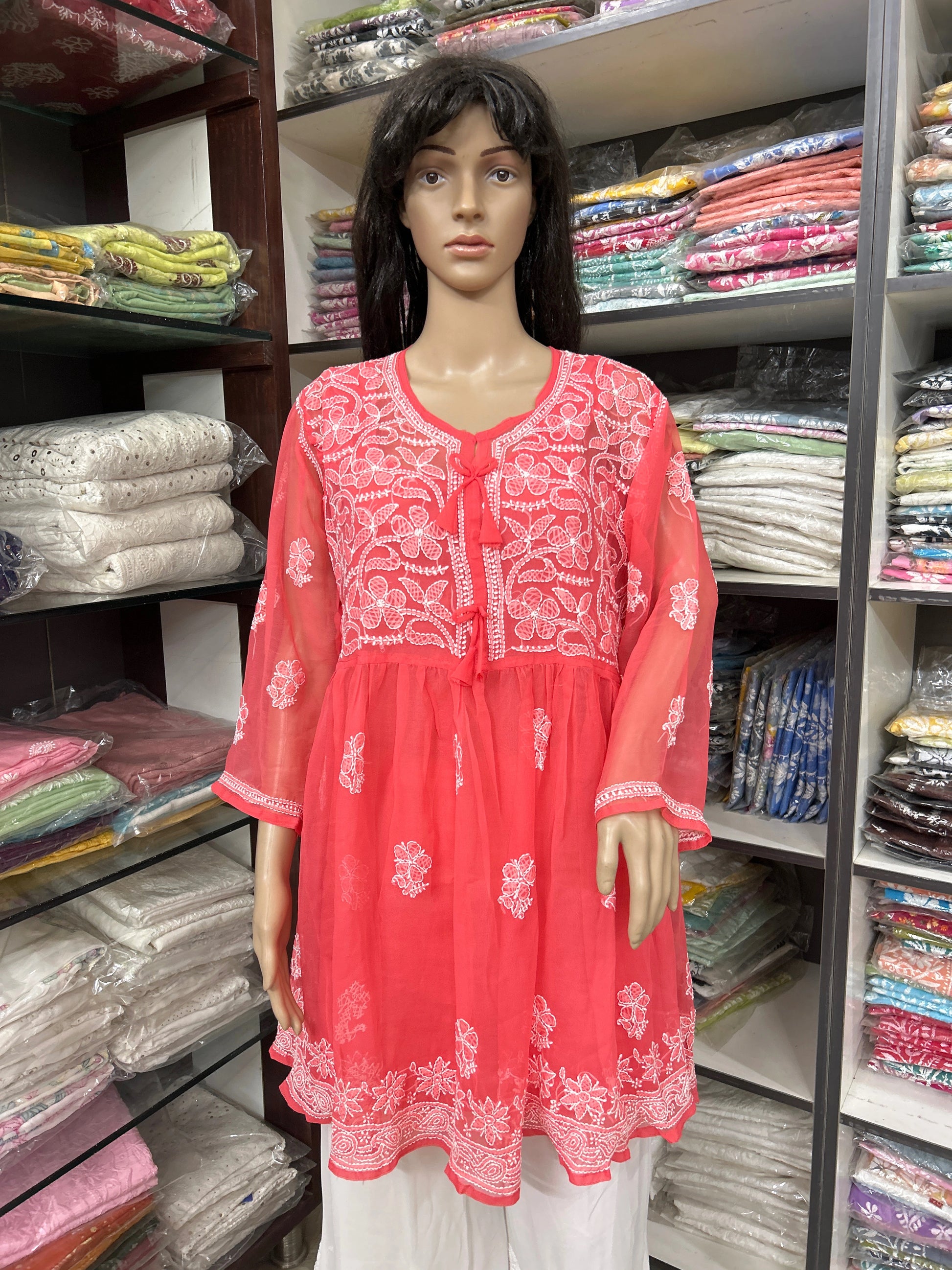 Mannequin wearing a red embroidered top in a fabric store