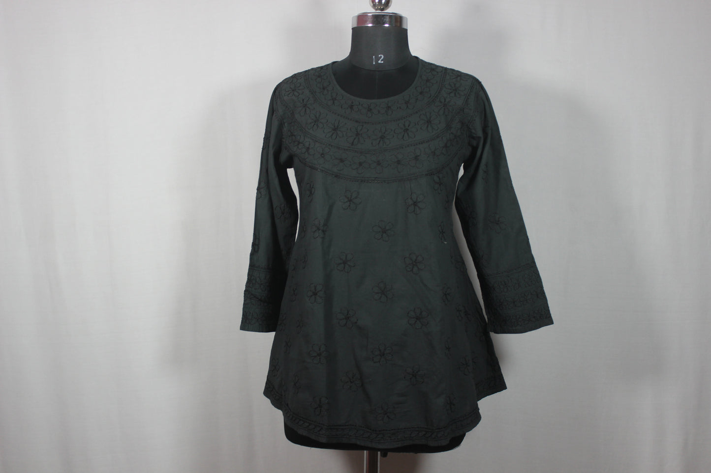 lucknowi chikankari Dark green dress on a mannequin against a plain background