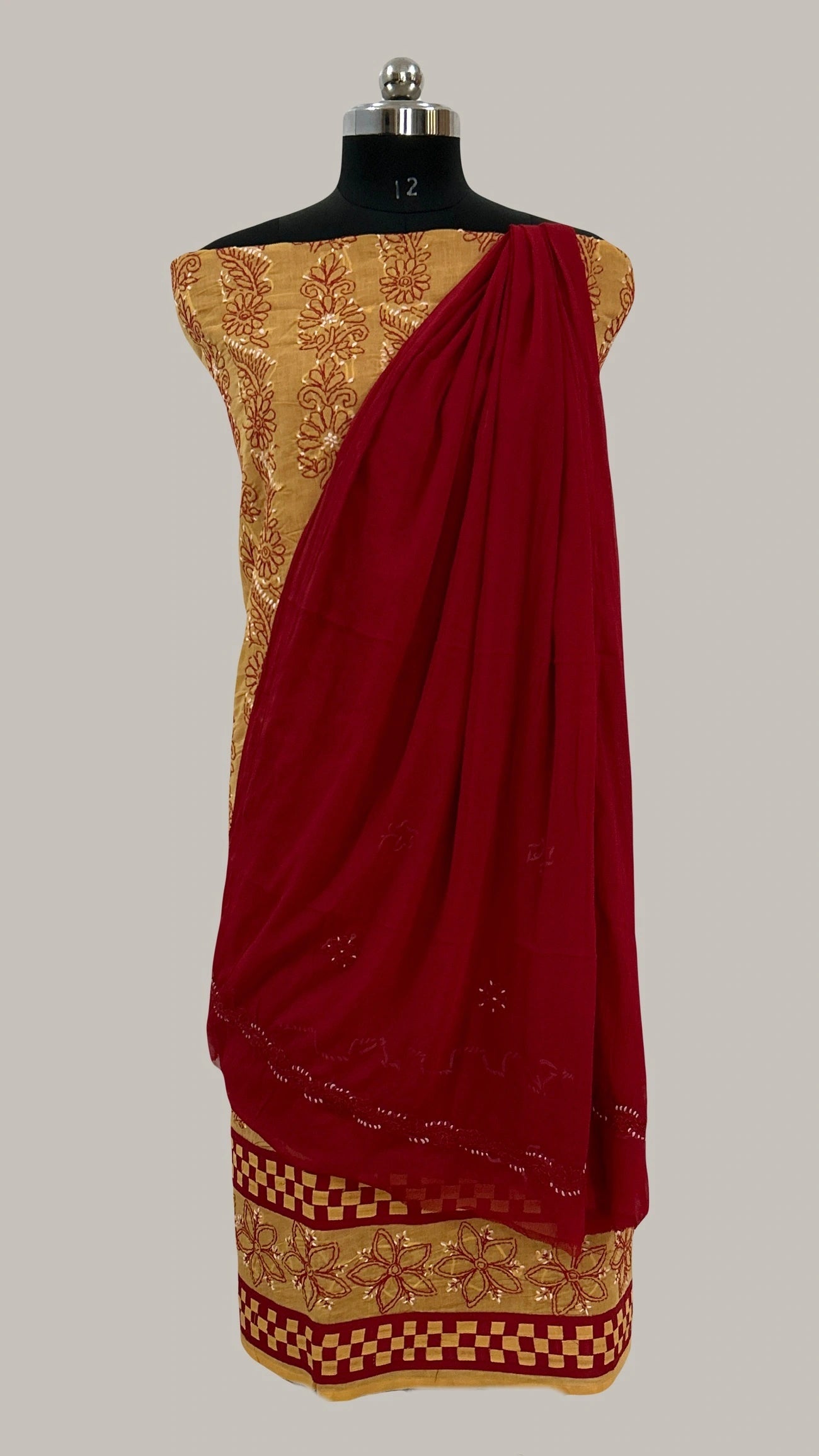Lucknowi chikankari Red saree with gold border on a mannequin against a gray background