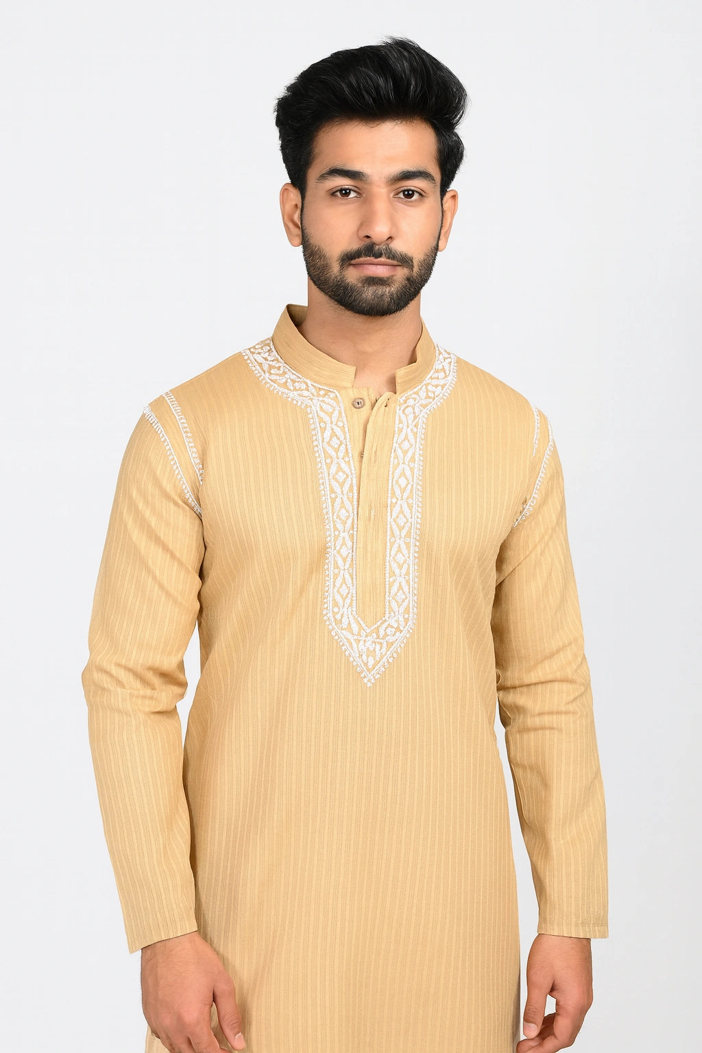 Man wearing a beige kurta with white embroidery on a white background