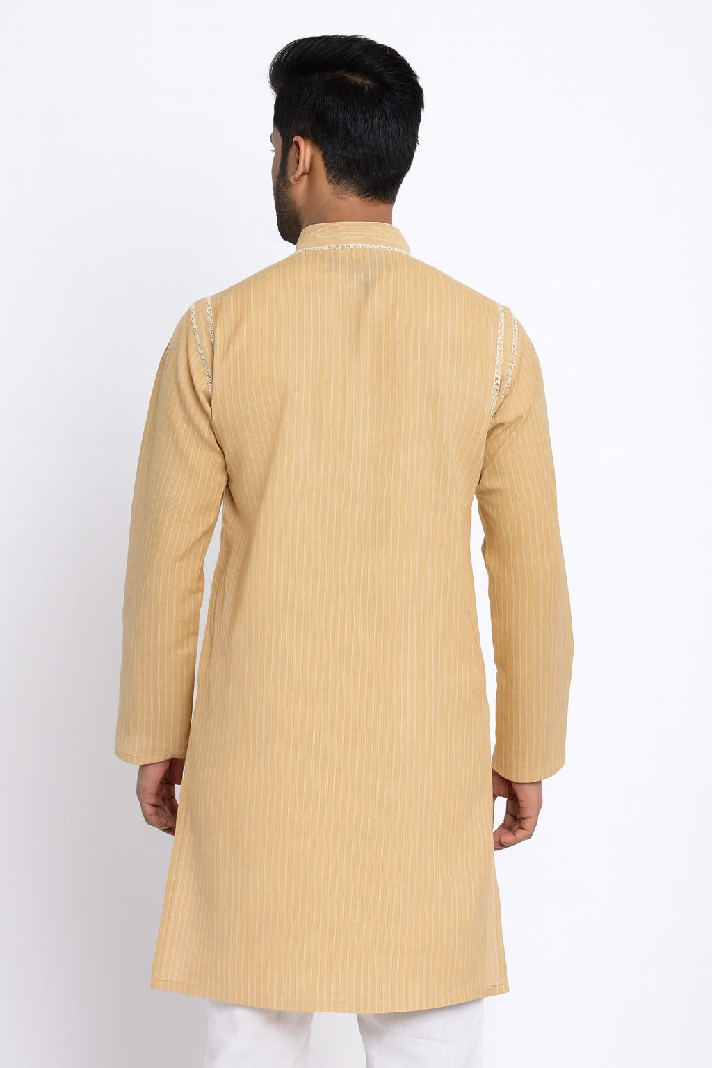 Man wearing a lucknowi chikankari beige kurta with white pants on a white background