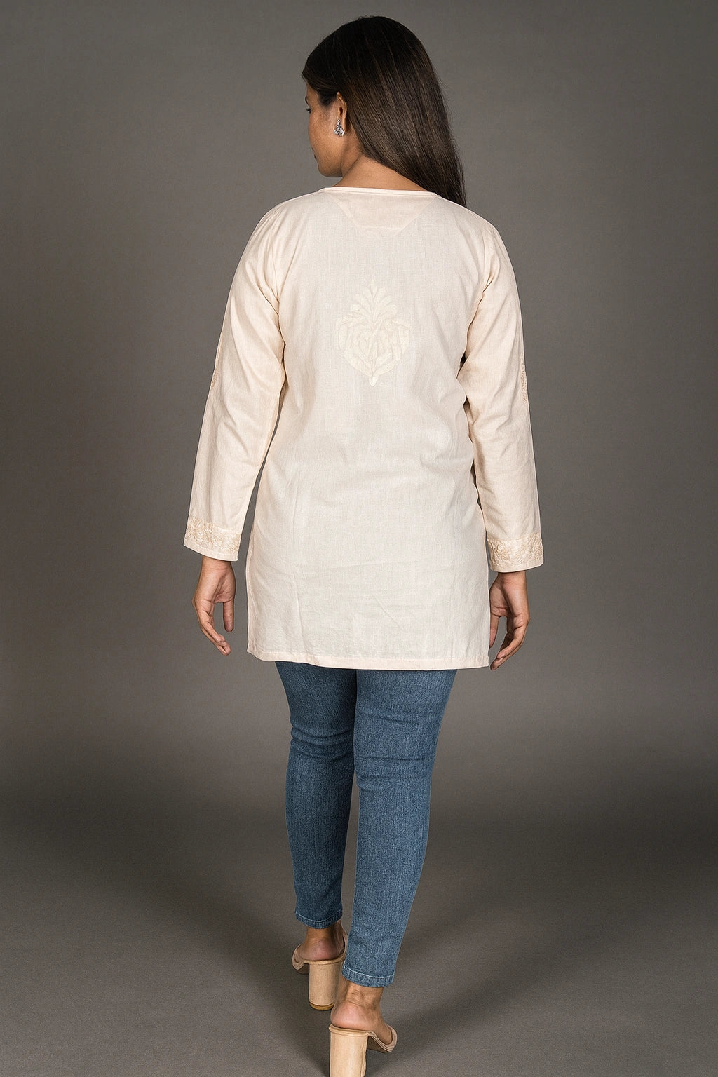 lucknowi chikankari Woman wearing a beige long-sleeve top and blue jeans on a gray background