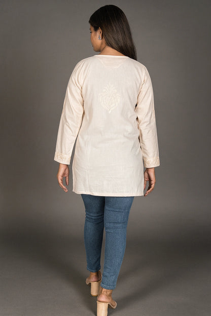 lucknowi chikankari Woman wearing a beige long-sleeve top and blue jeans on a gray background