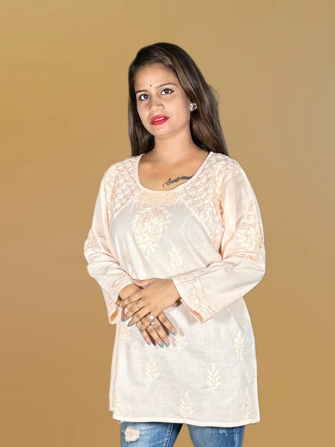 lucknowi chikankari Woman wearing a beige lace top against a gold background
