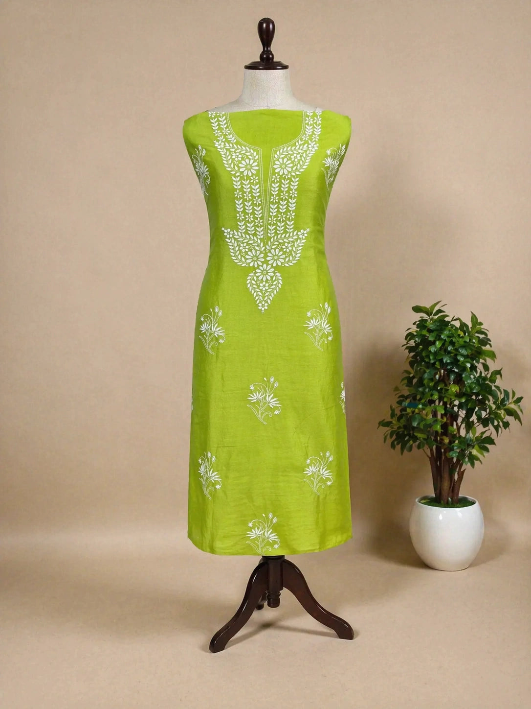 Lucknowi Chikankari Green dress with white floral patterns on a mannequin against a beige background