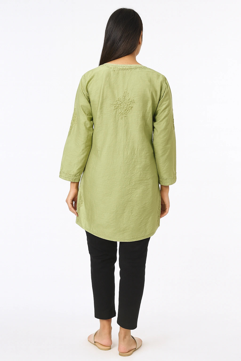 Woman wearing a lucknowi chikankari light green long-sleeve top with black pants on a white background