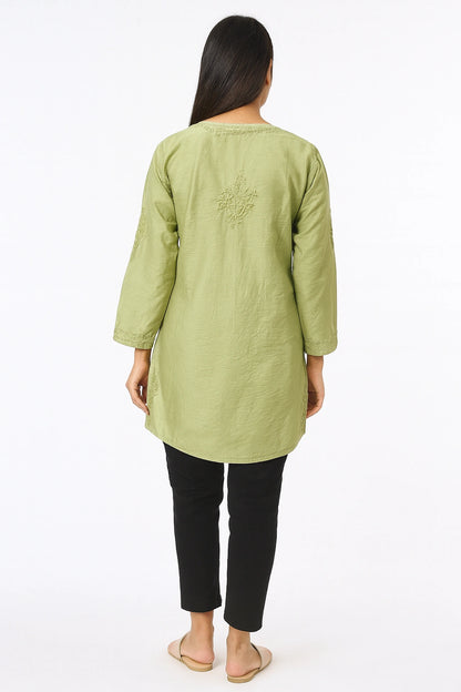 Woman wearing a lucknowi chikankari light green long-sleeve top with black pants on a white background