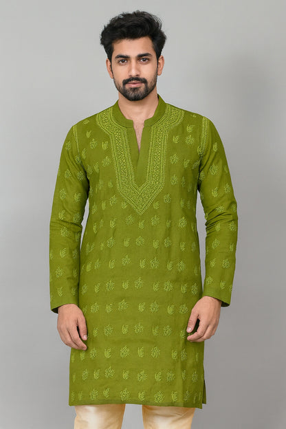 A man wearing a sage green kurta with light green floral embroidery and a split neckline, paired with cream trousers, standing against a solid gray background.