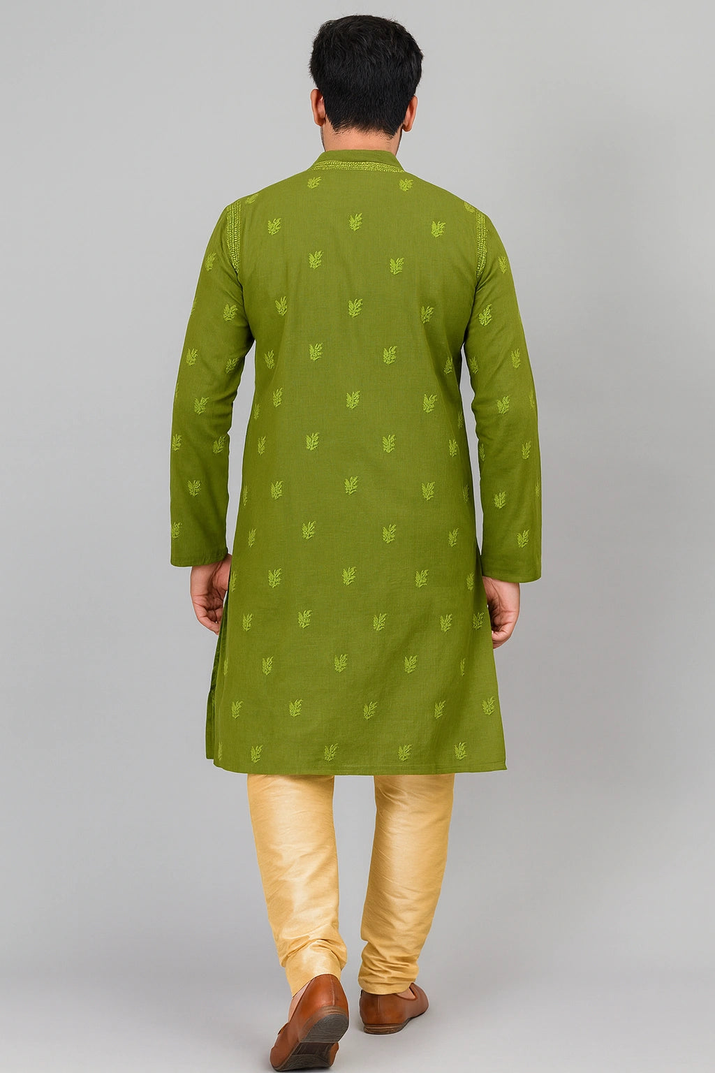 Lucknowi Chikankari A man viewed from behind wearing a green kurta with small repeating motifs and light yellow trousers, standing against a plain light gray studio background.