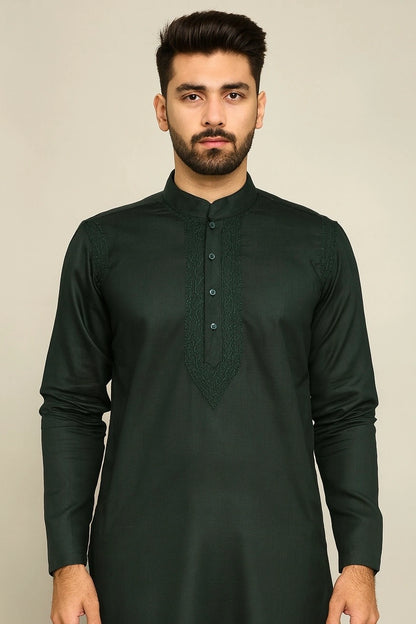 Man wearing a dark green kurta against a beige background