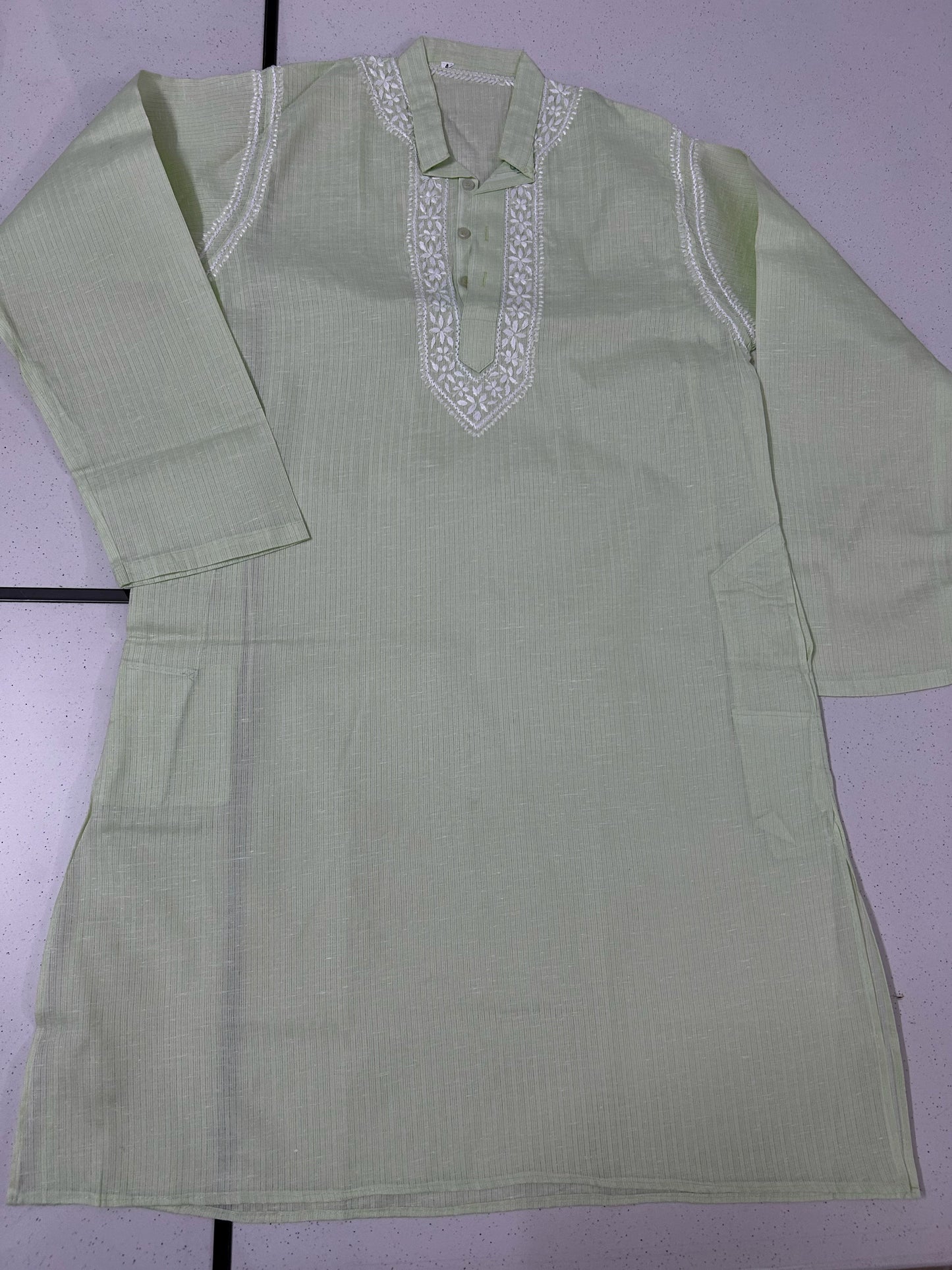 Light green kurta with white embroidery on a light purple background