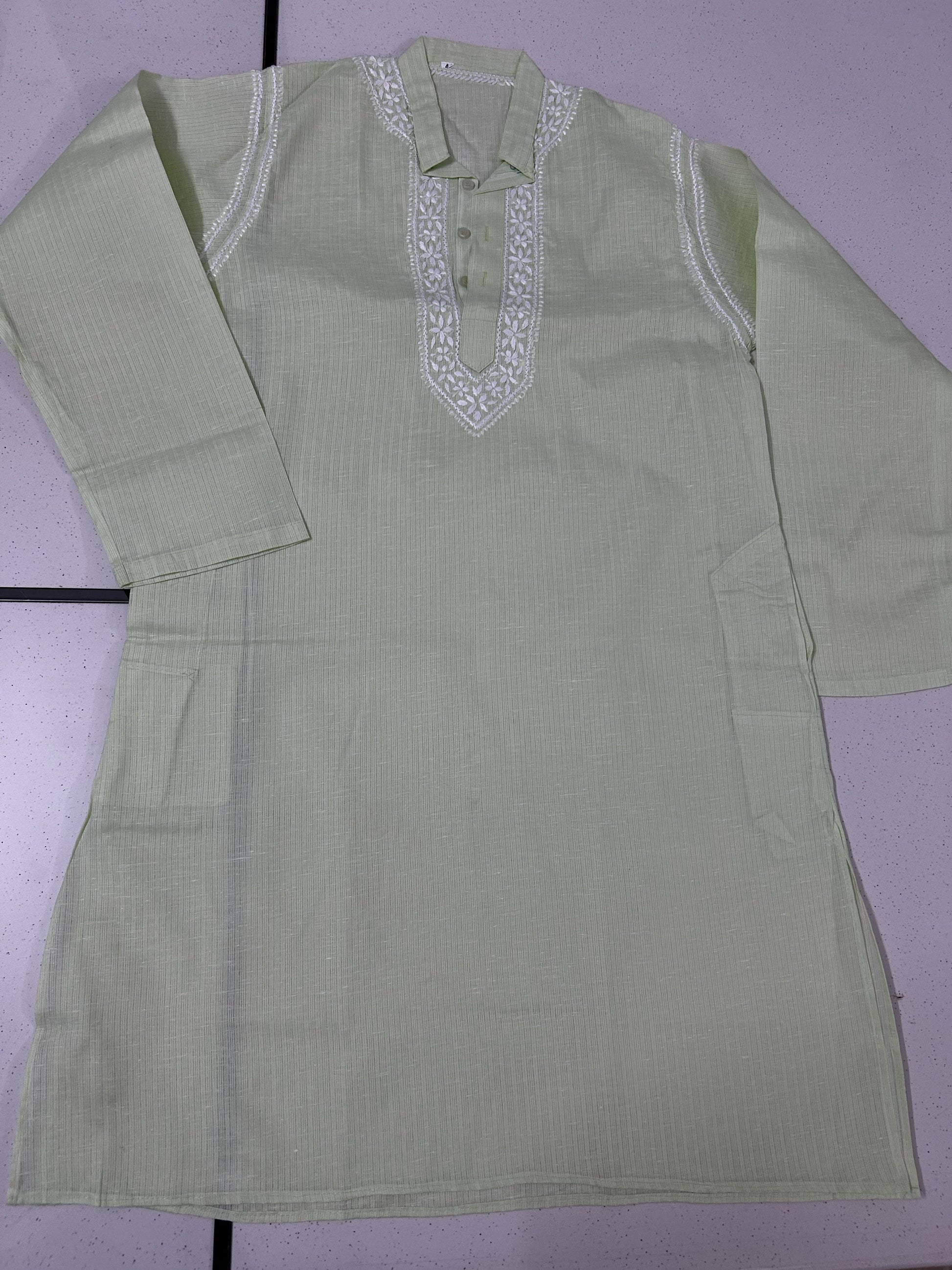 Light green kurta with white embroidery on a light purple background