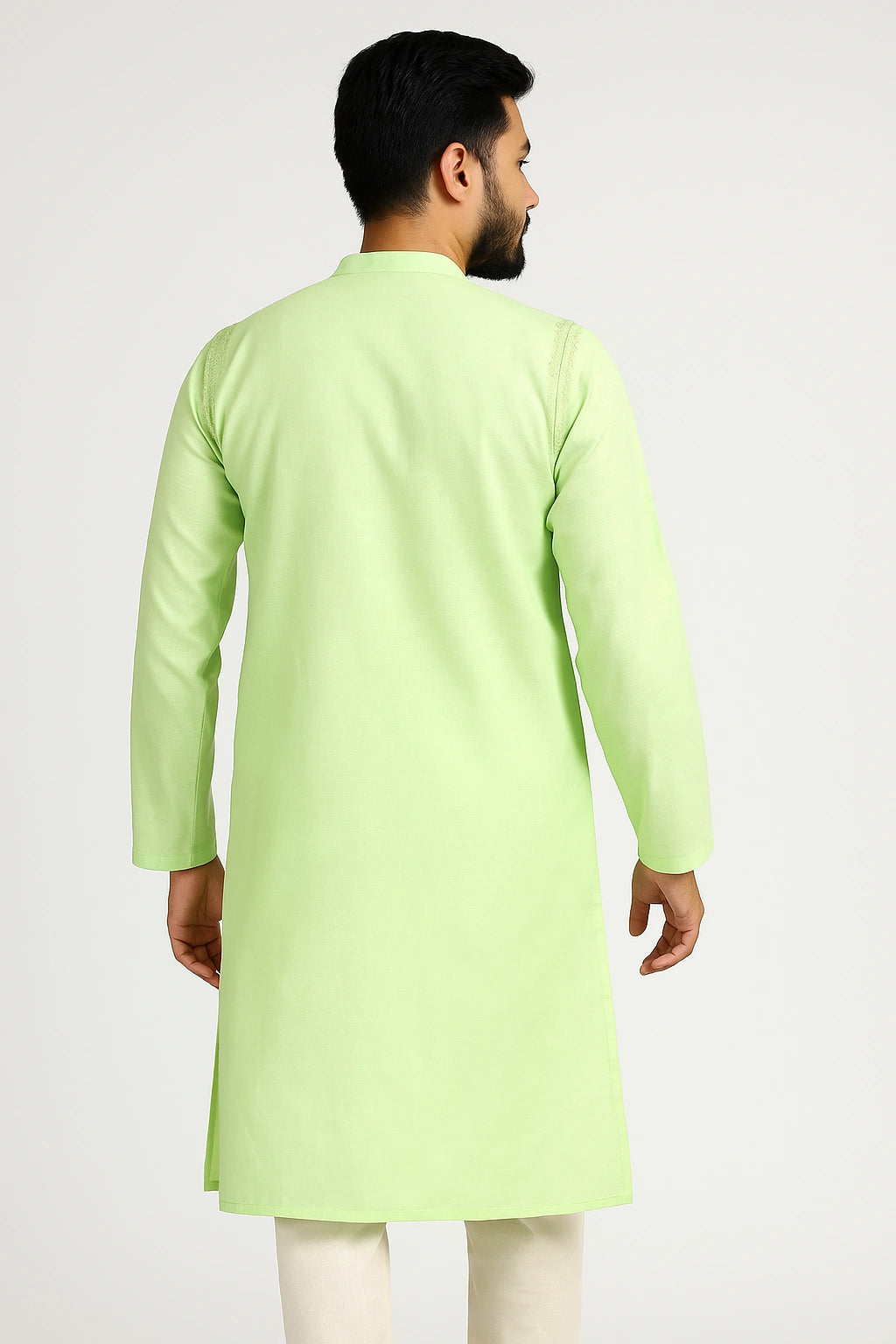 Man wearing a lucknowi chikankari light green kurta with white pants on a white background