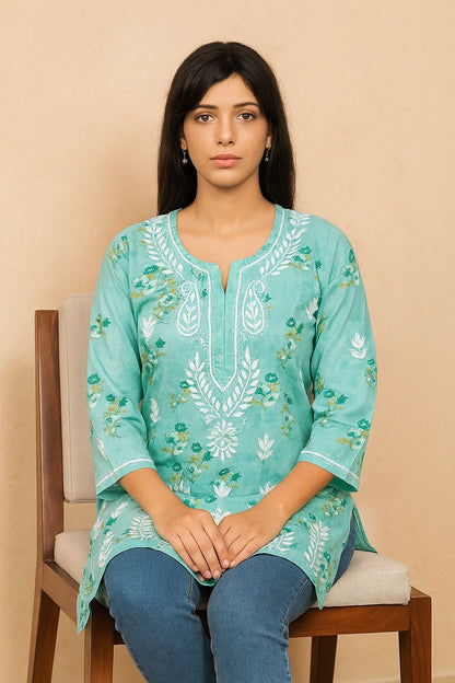 Woman wearing a green embroidered kurta on a beige background