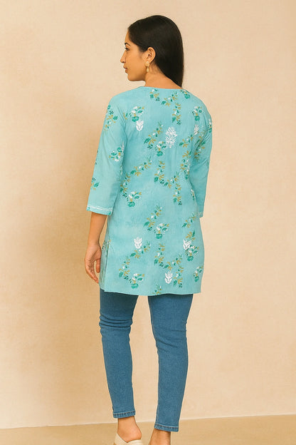 Person wearing a lucknowi chikankari light green top with a subtle pattern on a beige background